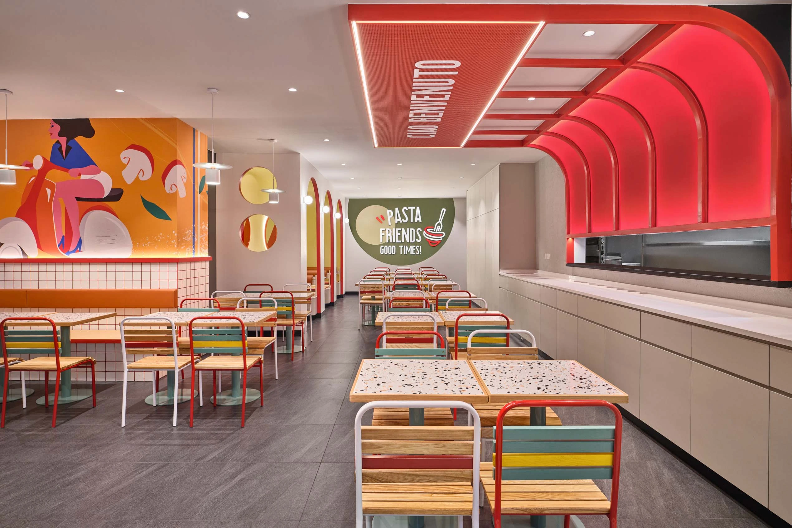 PastaMania Lot One dining area with red LED arch ceiling feature, terrazzo tables, and colourful mural wall