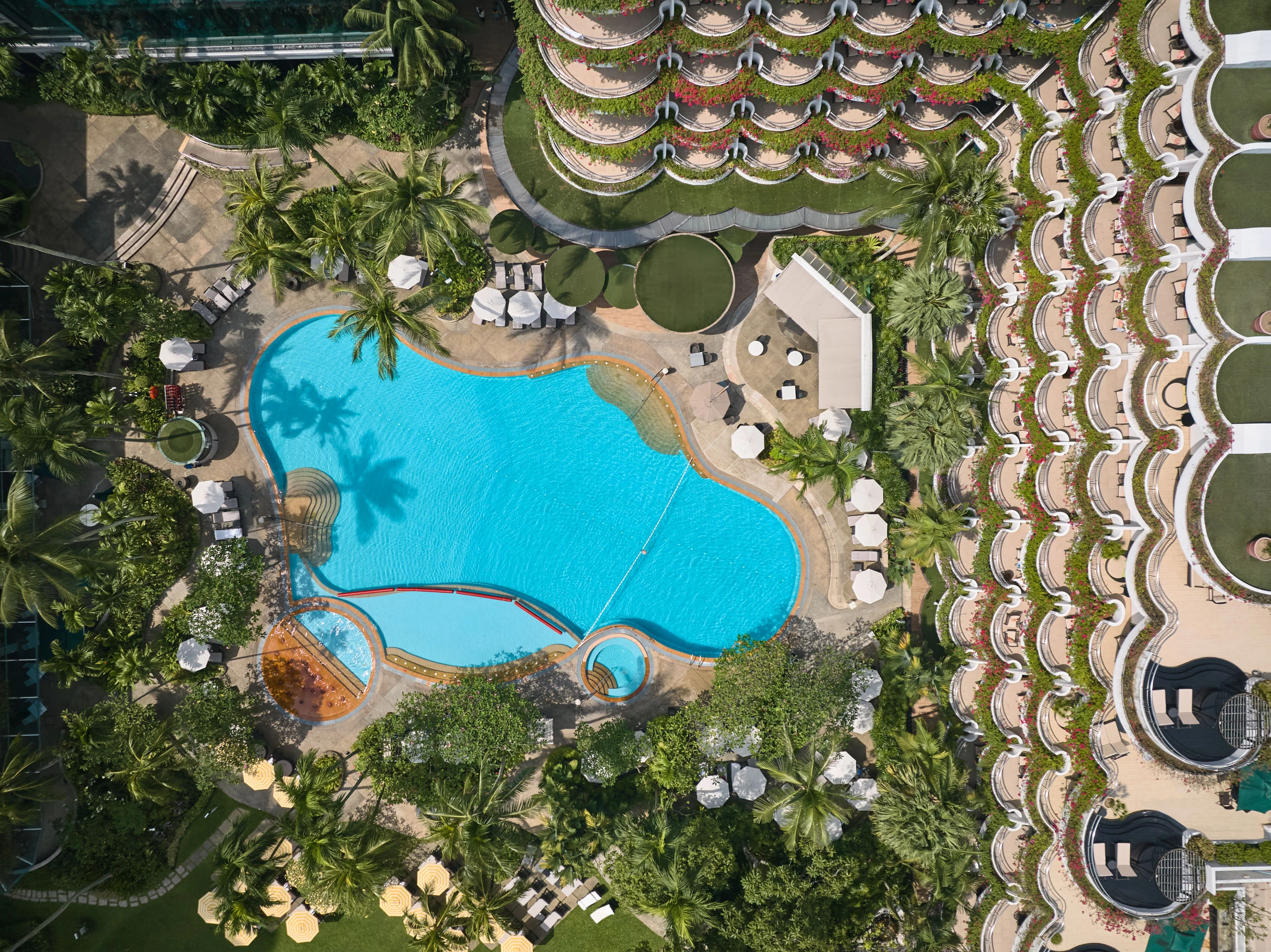 Bird's eye aerial view of Shangri-La Hotel Singapore freeform pool and tropical landscaping