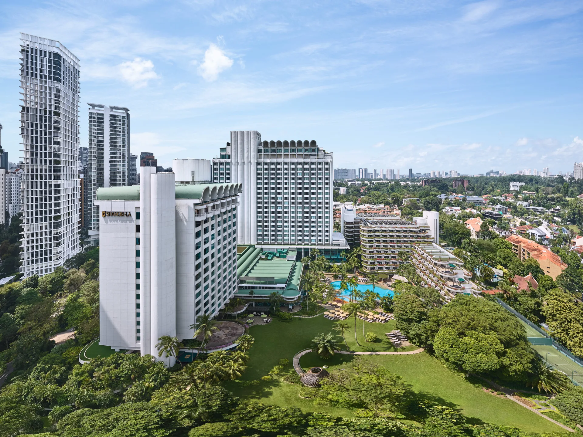 Aerial drone view of Shangri-La Hotel Singapore with Tower Wing, Garden Wing, pool and Orchard Road skyline