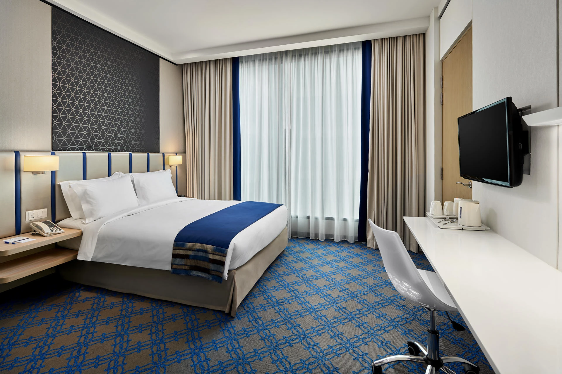 Accessible king room with geometric accent wall and work desk — Holiday Inn Express Katong hotel photography