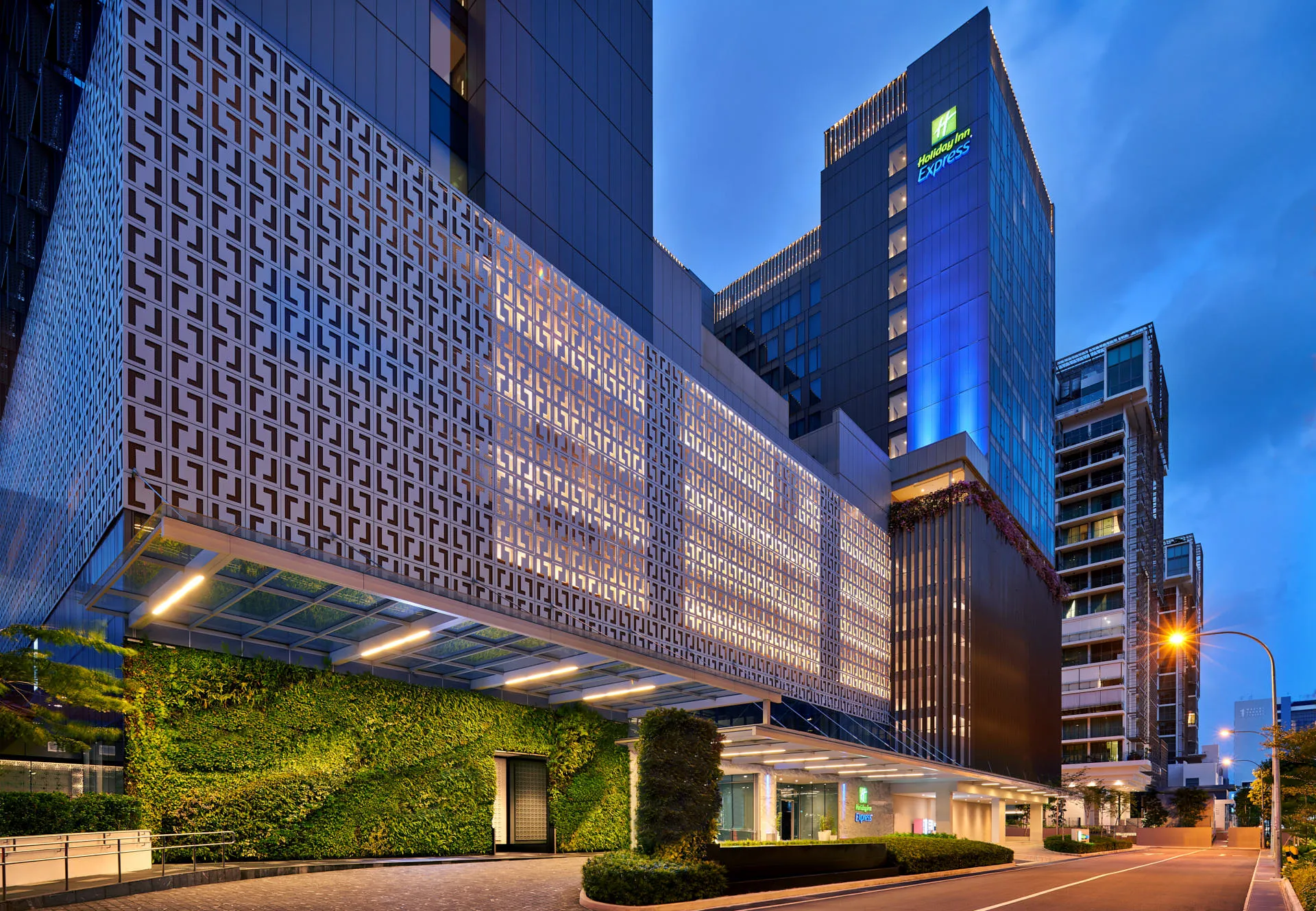 Hotel tower with geometric facade and green wall at twilight — Holiday Inn Express Katong architectural photography