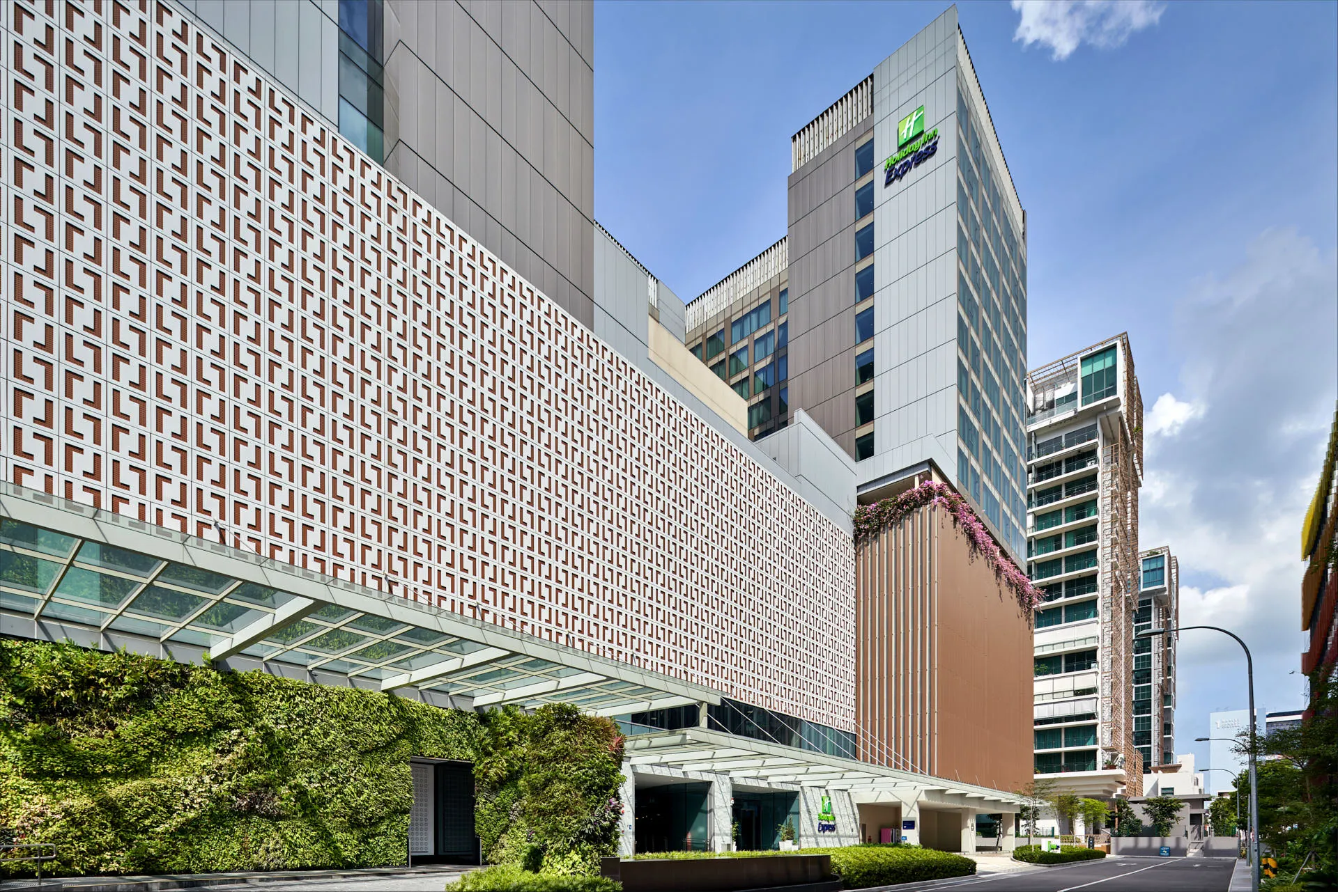 Hotel exterior with lattice facade and living wall under blue sky — Holiday Inn Express Katong architectural photography