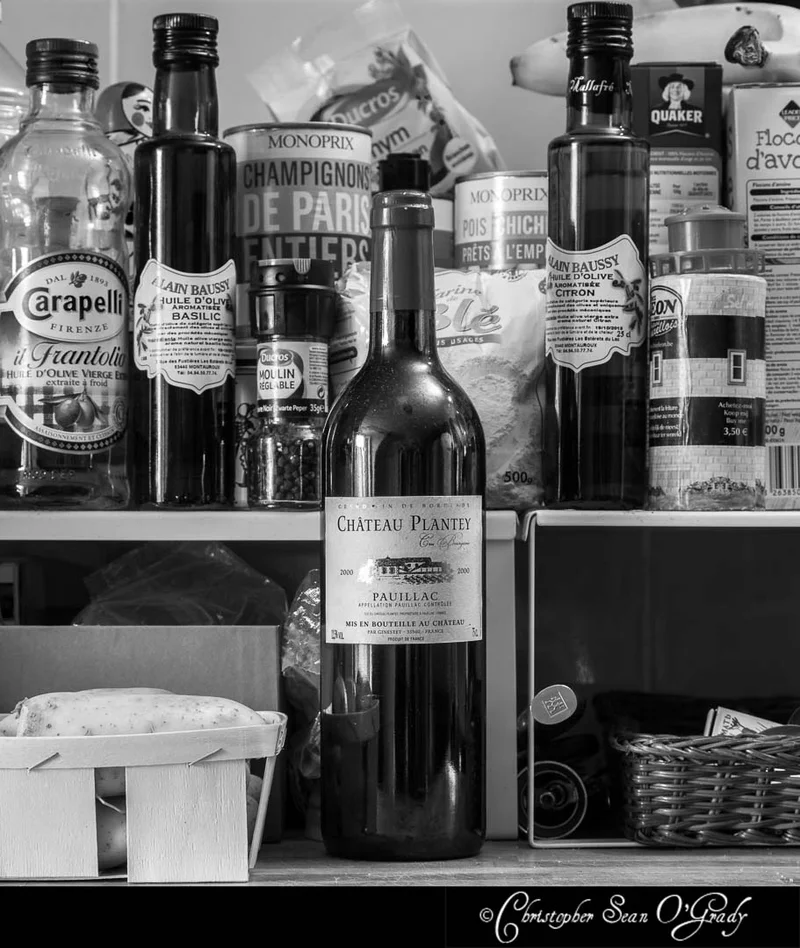 Chateau Plantey Pauillac 2000 wine on a French kitchen shelf with pantry items