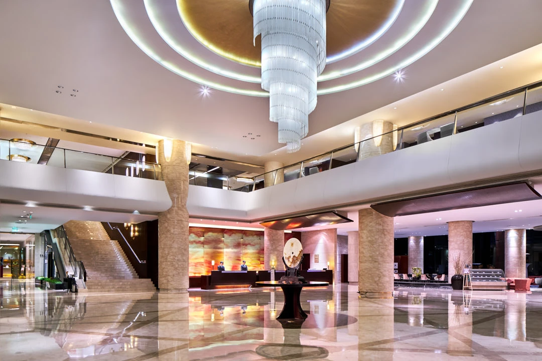 Double-height lobby with crystal chandelier, marble floors and grand staircase — Crowne Plaza Tianjin Binhai hotel photography