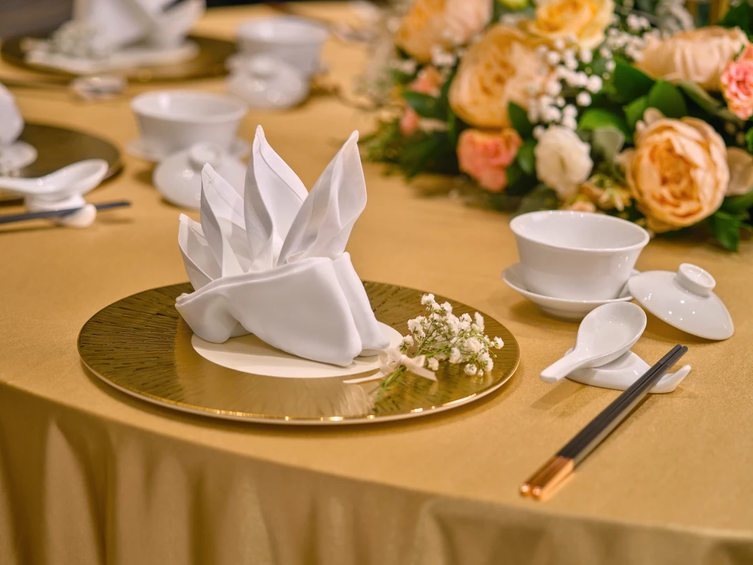 Chinese banquet place setting with gold charger, teacup and baby’s breath - voco Orchard Singapore wedding photography