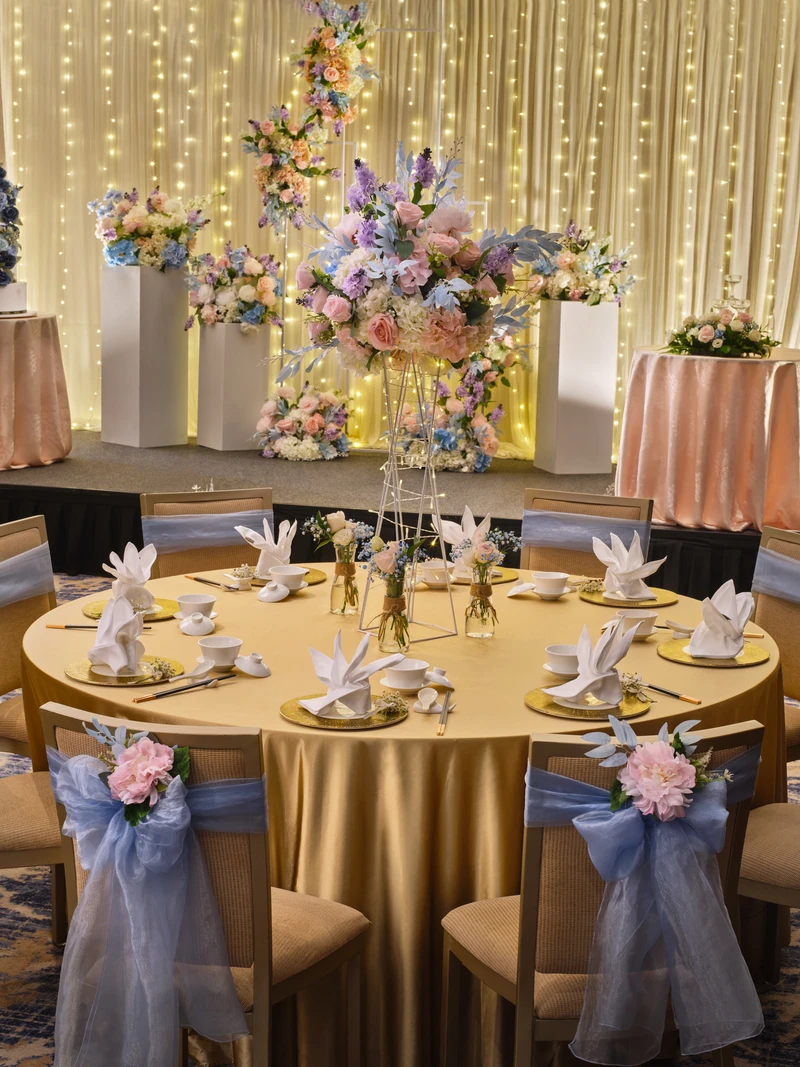 Chinese banquet table with gold chargers, pastel floral centrepiece and fairy lights - voco Orchard Singapore wedding photography