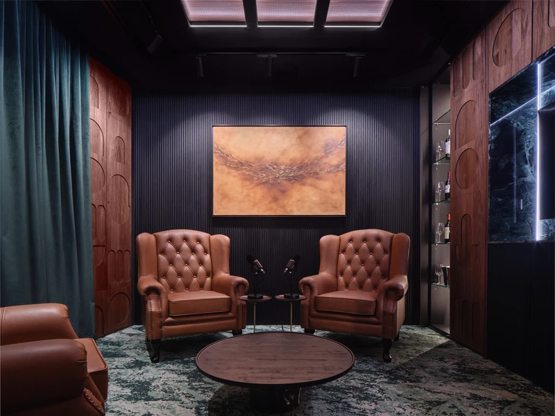 Private meeting lounge with two sophisticated leather armchairs and framed artwork, creating a quiet atmosphere for discussions with bar open.