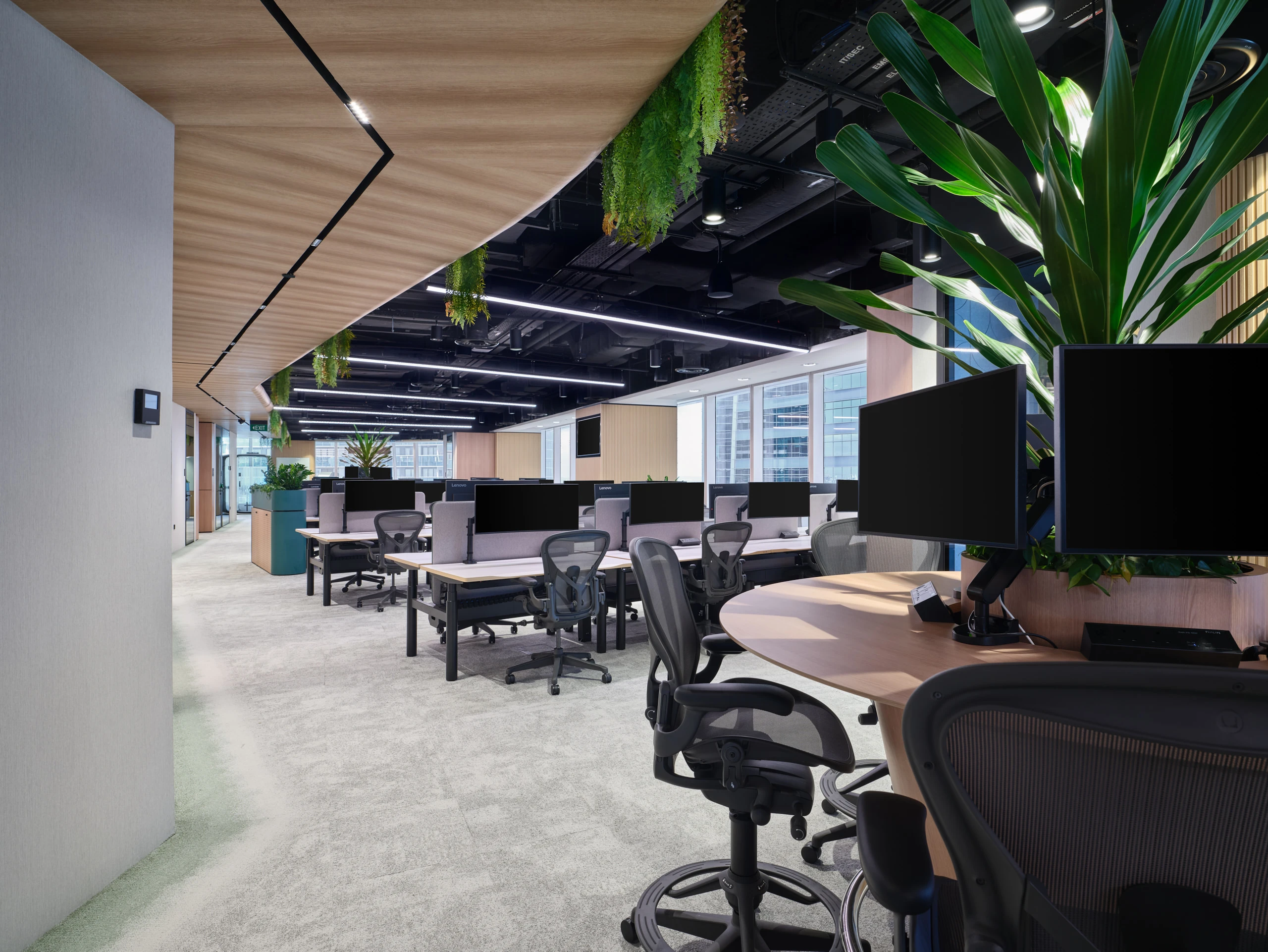 Open-plan workstation area with rows of desks and natural light