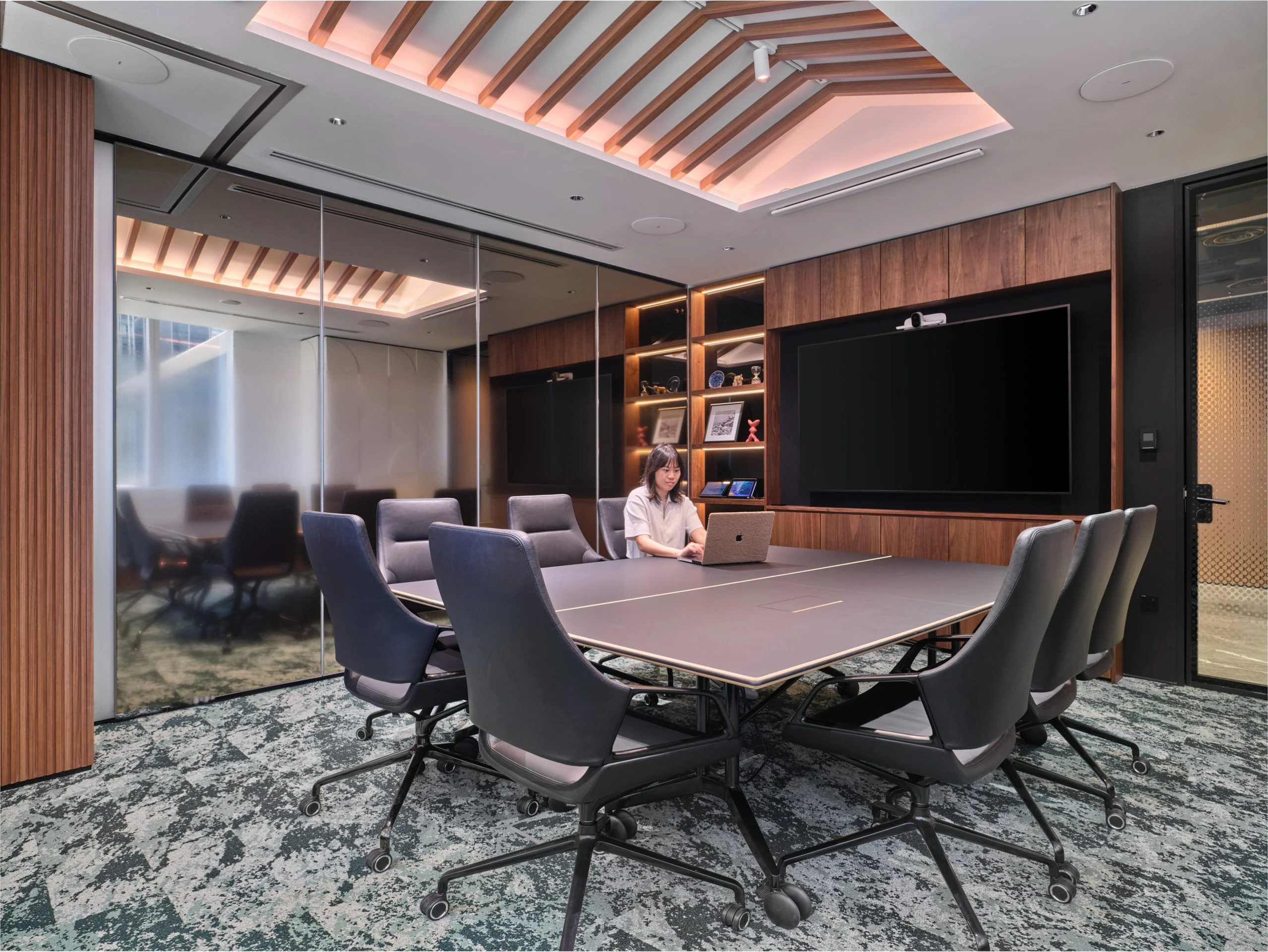 Boardroom with long conference table and dramatic overhead lighting