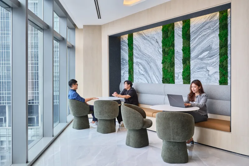 Three people at a banquette lounge with green moss and marble feature wall