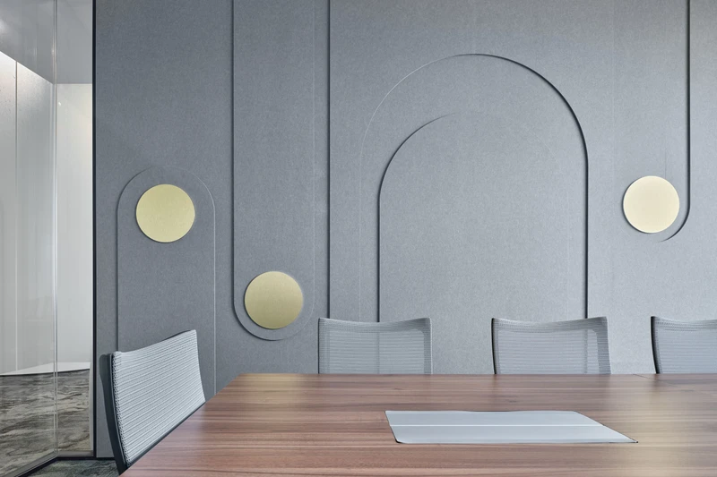 Meeting room with grey felt acoustic wall panels featuring arch designs and gold accents
