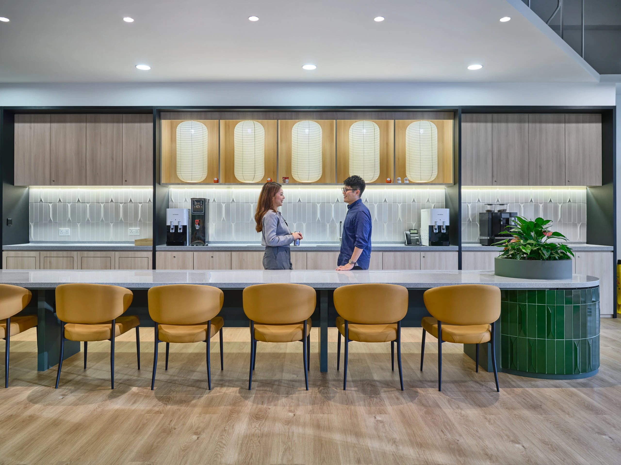 Office pantry with curved counter, lantern pendants and walnut cabinetry