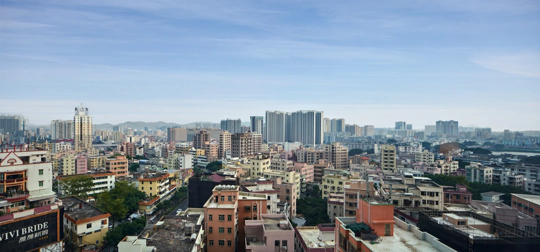 Panoramic Shenzhen cityscape from hotel window with mountain backdrop