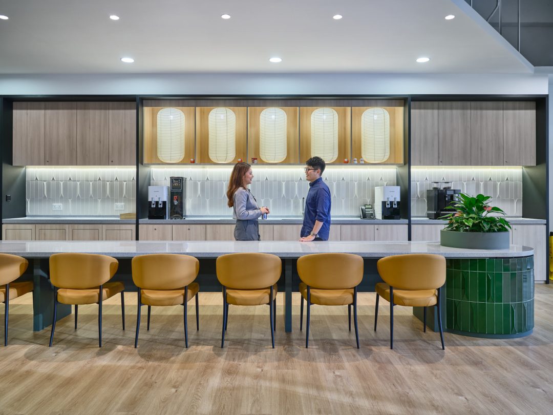 Modern office kitchen with seating area.