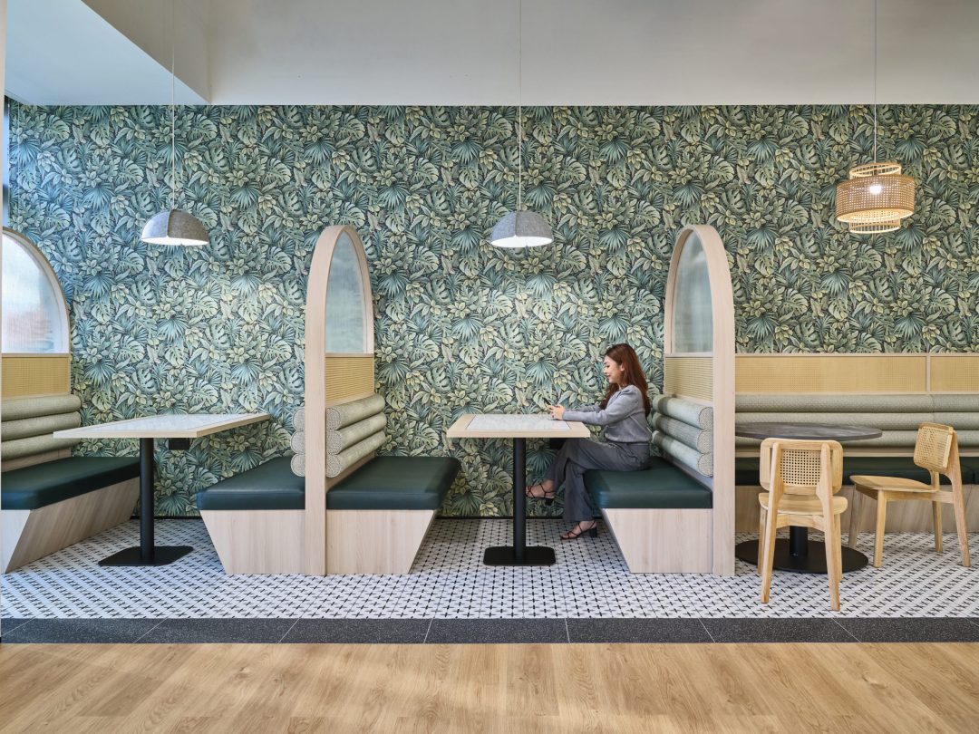 Modern cafe with tropical wallpaper seating.