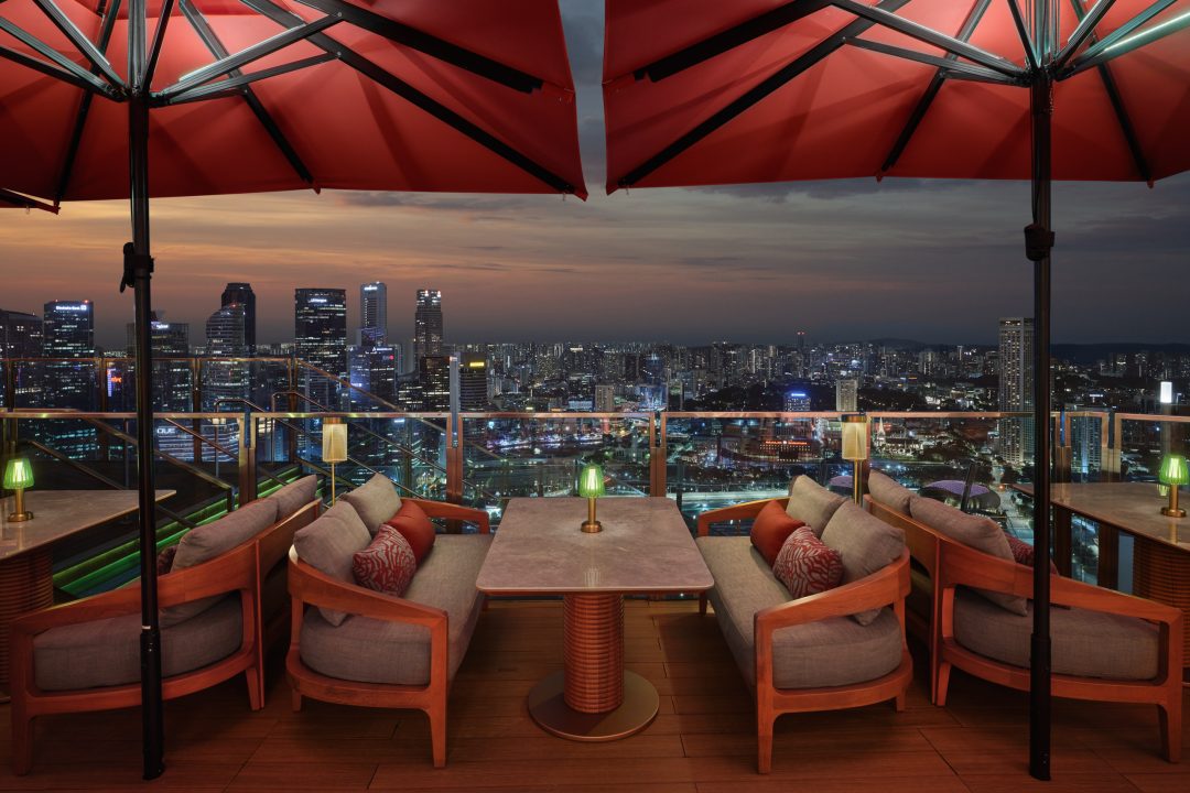 Restaurant and bar photography featuring the lounge furniture at CÉ LA VI Singapore, composed to perfectly frame the dramatic sunset over the city.