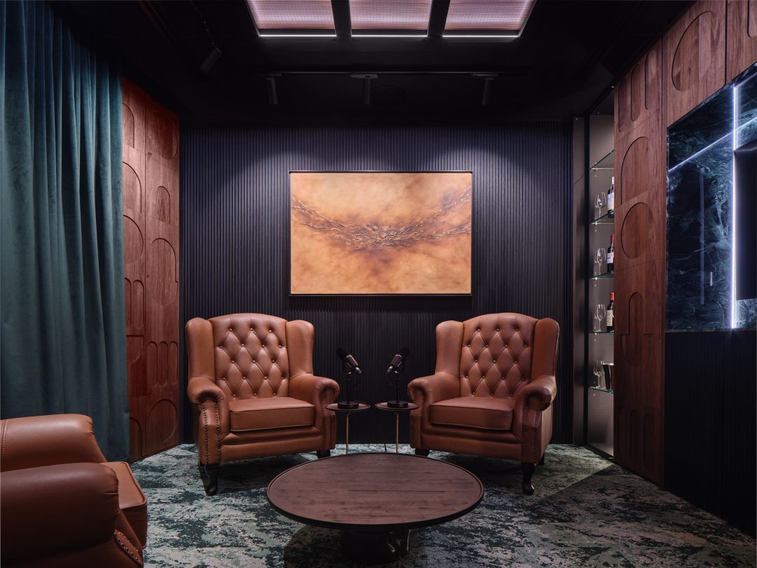 Private meeting lounge with two sophisticated leather armchairs and framed artwork, creating a quiet atmosphere for discussions with bar open.