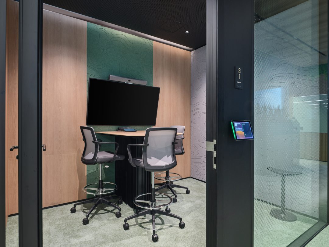 A private, glass-walled office pod providing a quiet, sound-proofed space for focused work within a larger open-plan environment.