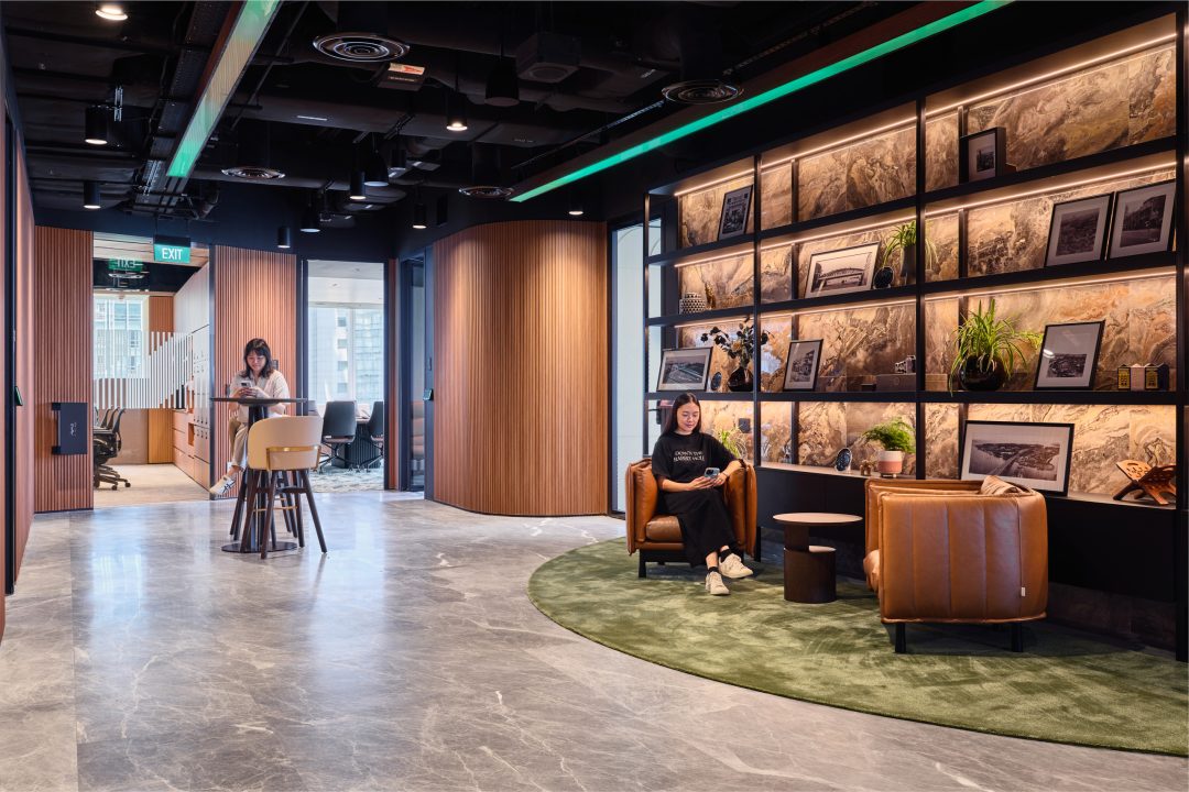 Expansive multi-functional office hub at CBRE with a central coffee bar, diverse seating areas, and intricate architectural woodwork.